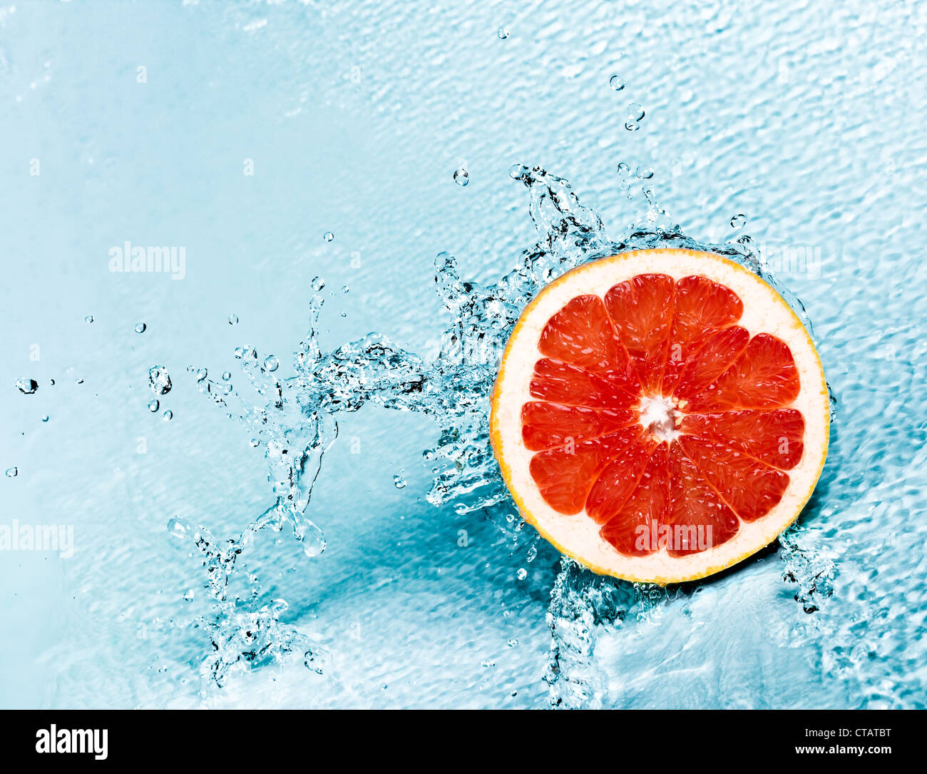 Acqua fresca schizzi sul pompelmo rosso Foto Stock