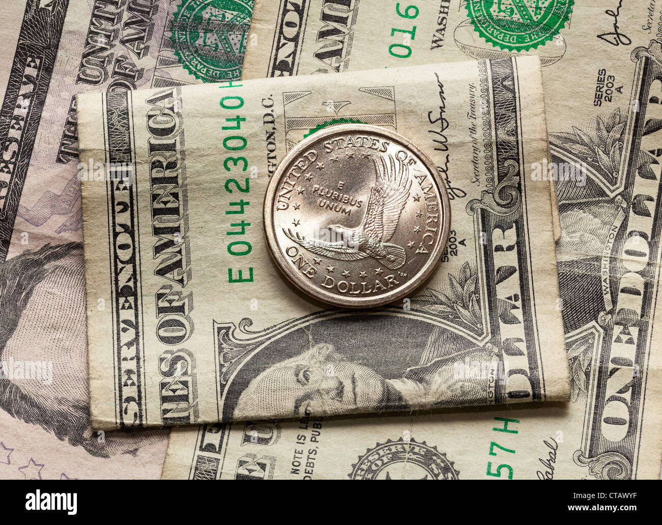 Il contrasto del dollaro e mezzo dollaro moneta con una carta usurata bill Foto Stock