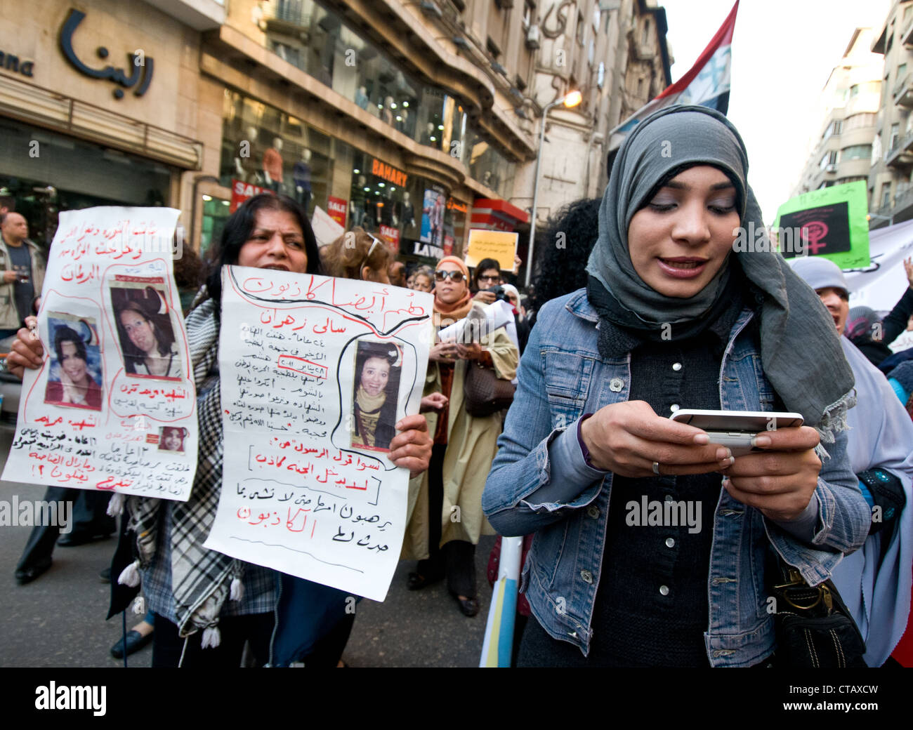 La giornata internazionale della donna marzo chiedono una maggiore rappresentanza nel governo cittadino Cairo-Egyptian giornalista texting Foto Stock