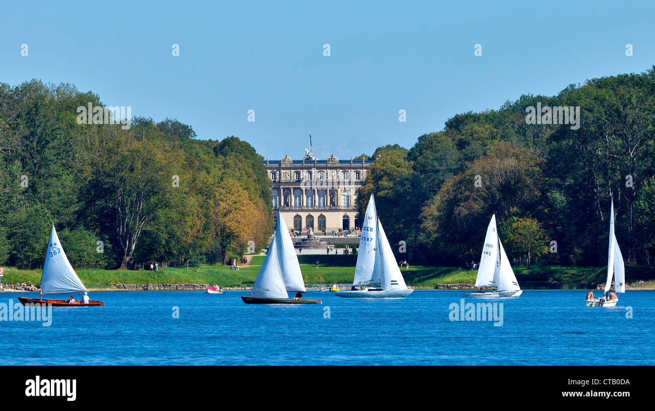 Barche a vela sul lago Chiemsee, Herrenchiemsee Palace in background, Chiemsee, Chiemgau, Alta Baviera, Germania Foto Stock
