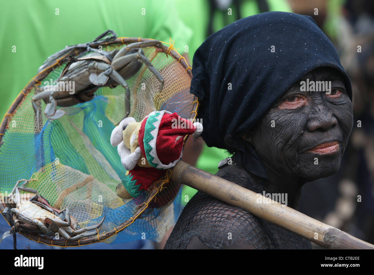 Donna con la pittura del viso azienda offerte presso Ati Atihan festival, Ibajay, Aklan, Panay Island, Visayas, Filippine Foto Stock