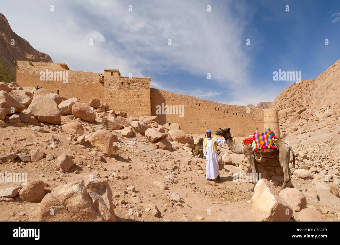 Un beduino locale guida turistica e il suo cammello il monastero di Santa Caterina dietro, Sinai, Egitto Foto Stock