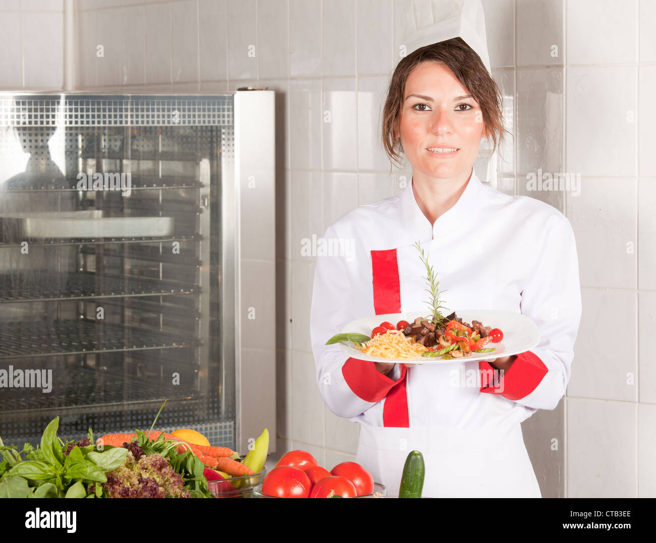 Ritratto di metà femmina adulta chef in cucina Foto Stock