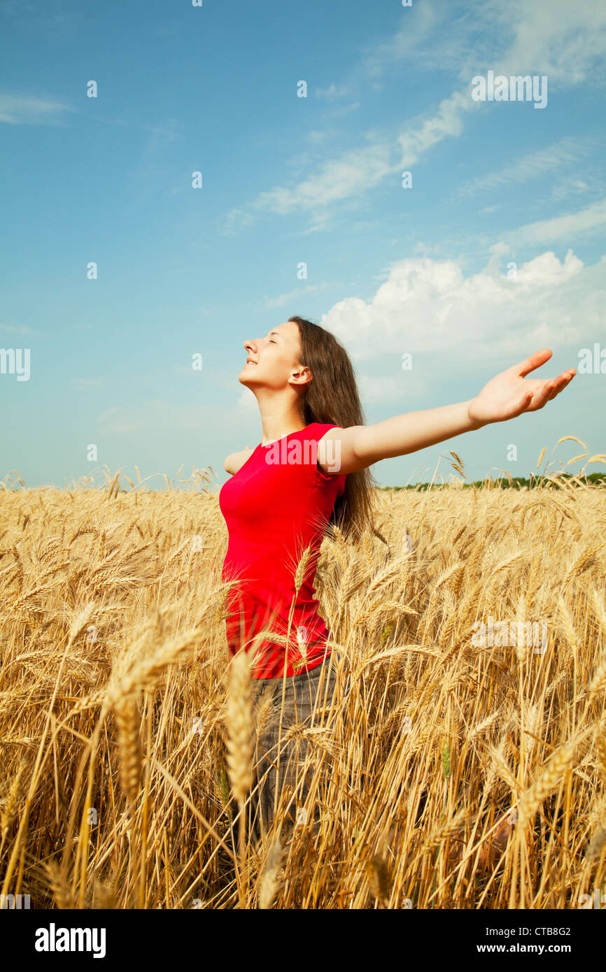 Teen girl soggiornare in un campo di grano con le braccia aperte Foto Stock