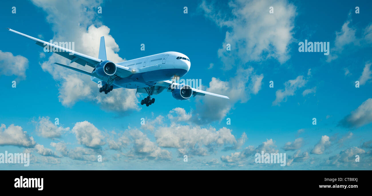 Piano di getto in un colore blu cielo nuvoloso è la manovra per l'atterraggio. Composizione panoramica Foto Stock
