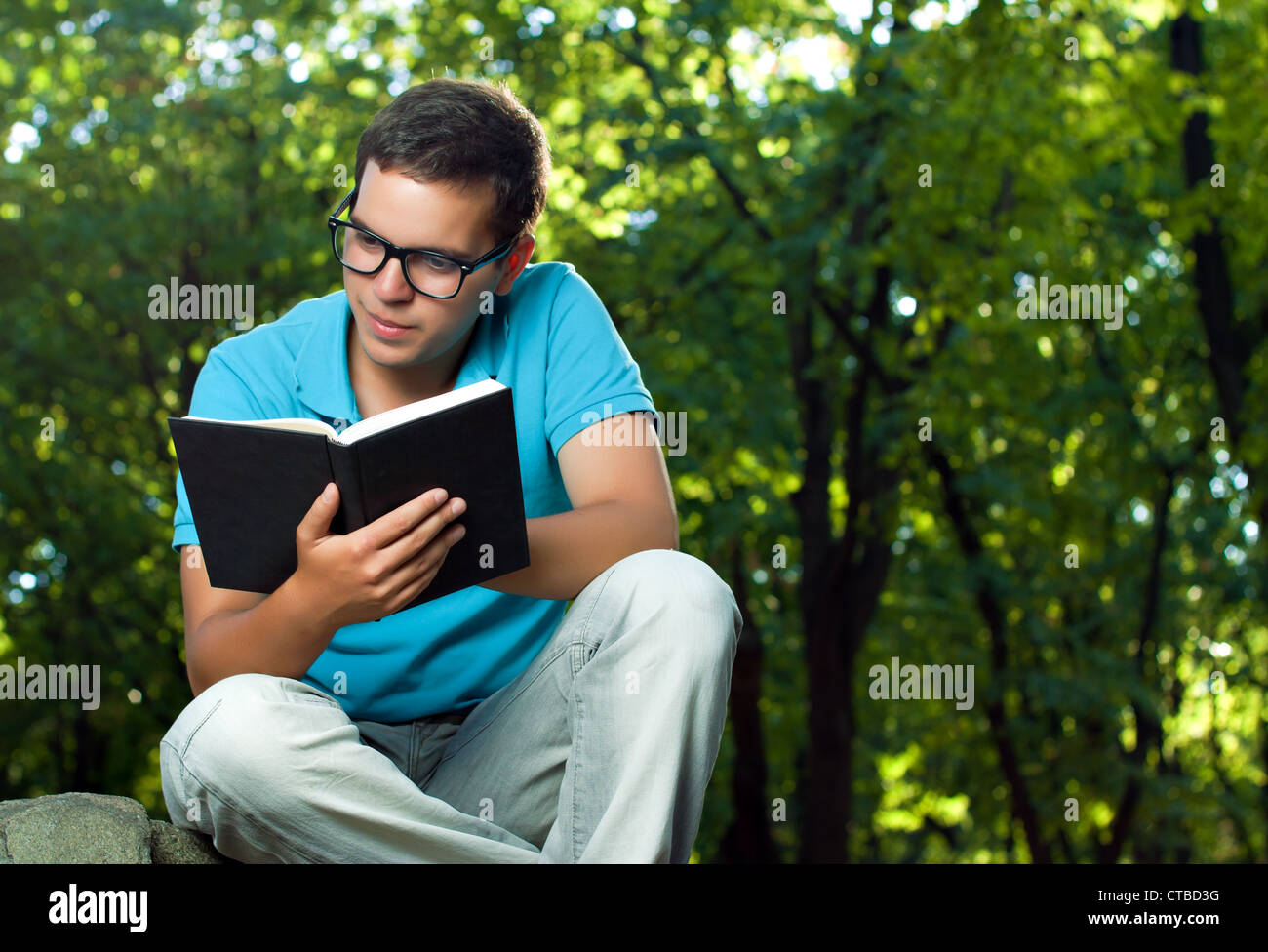 Giovane uomo libro di lettura nel parco Foto Stock