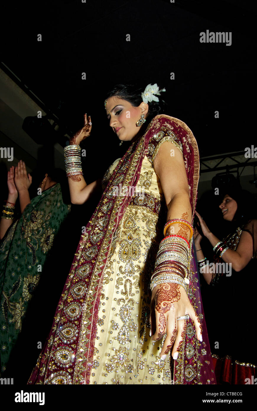 Giovane e bella East Indian sposa henna dye decorate mani braccia donne che danzano al ricevimento di nozze Foto Stock