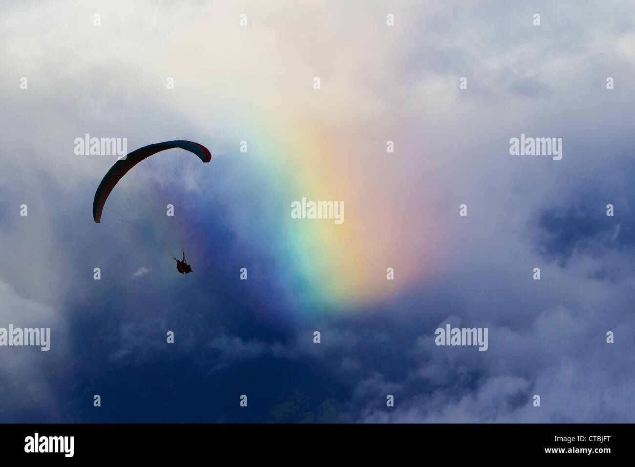 Parapendio contro il cielo nuvoloso e la natura Rainbow potrebbe suggerire l'Attrazione umana per i colori Foto Stock