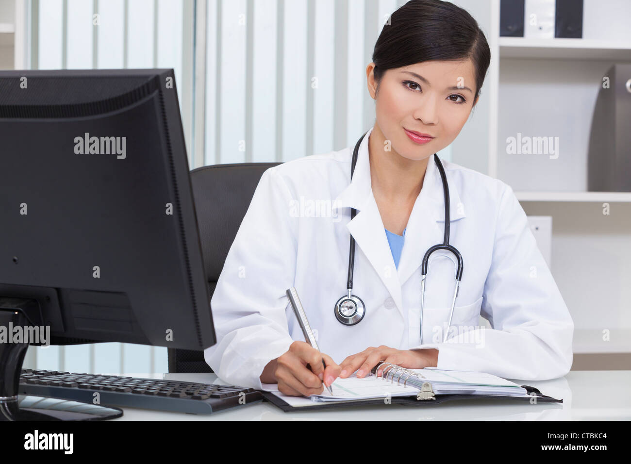 Un Cinese femmina asiatica medico iscritto in un ospedale di office Foto Stock