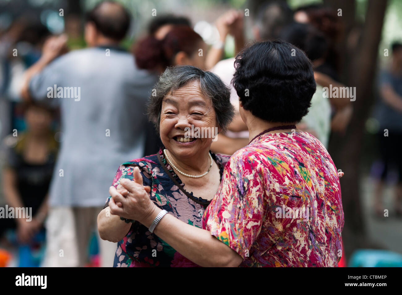 Anziani Le donne cinesi dancing e sorridente a Chengdu people's Park, Sichuan, in Cina Foto Stock