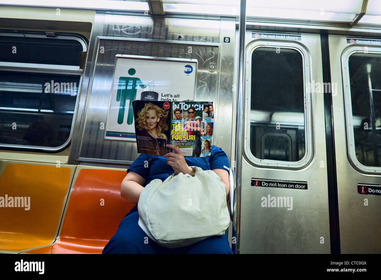 La donna a New York alla metropolitana la lettura di celebrità rivista con Tom Cruise e Katie Holmes e il loro bambino Suri sul coperchio. Foto Stock