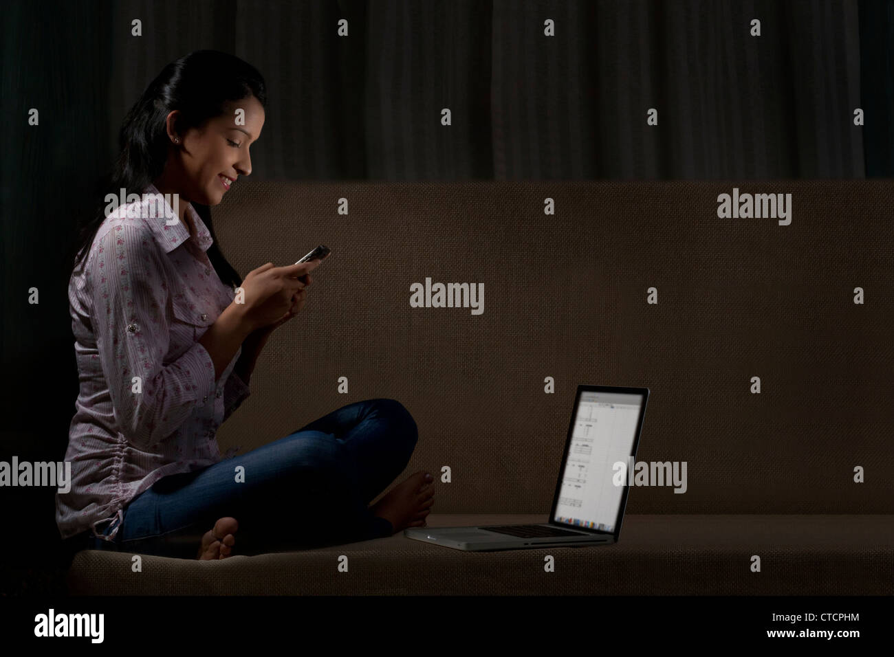 Giovane donna la lettura di un sms Foto Stock