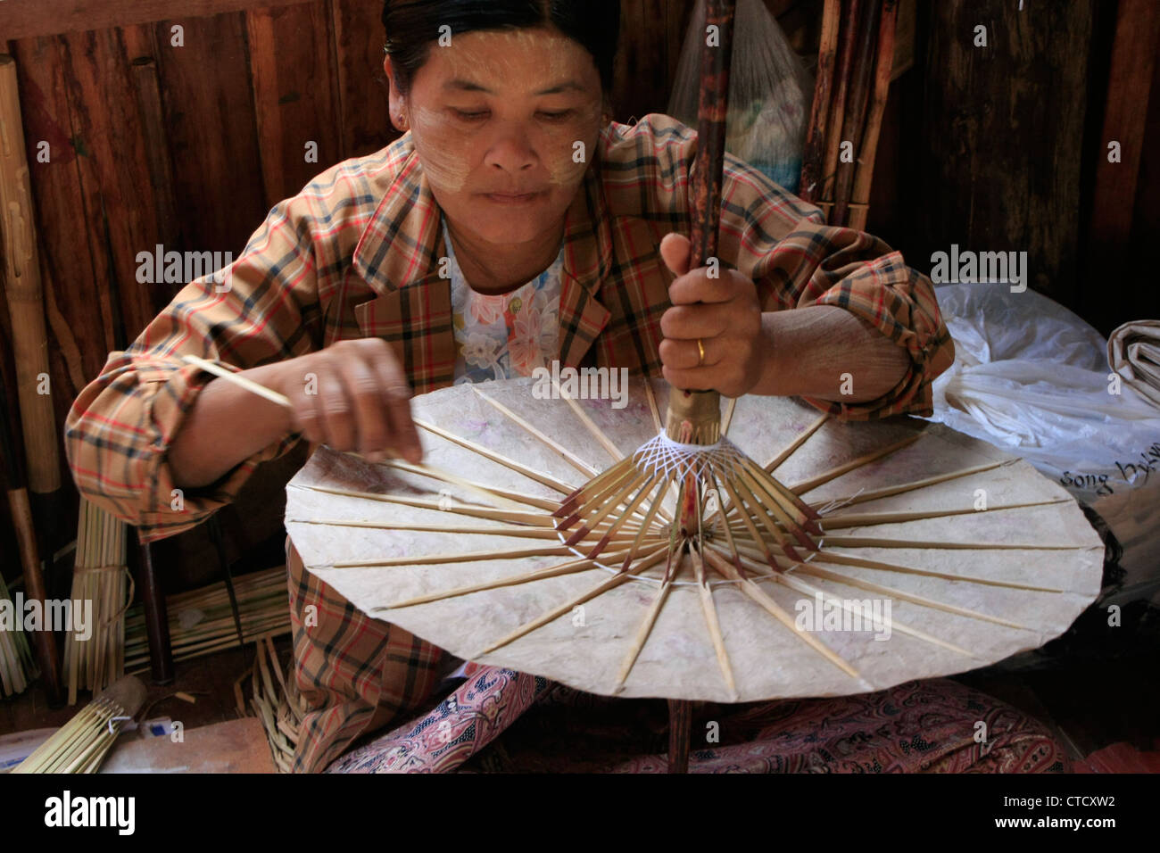 Donna birmano rendendo carta tradizionale ombrellone, Lago Inle, stato Shan, Myanmar, sud-est asiatico Foto Stock