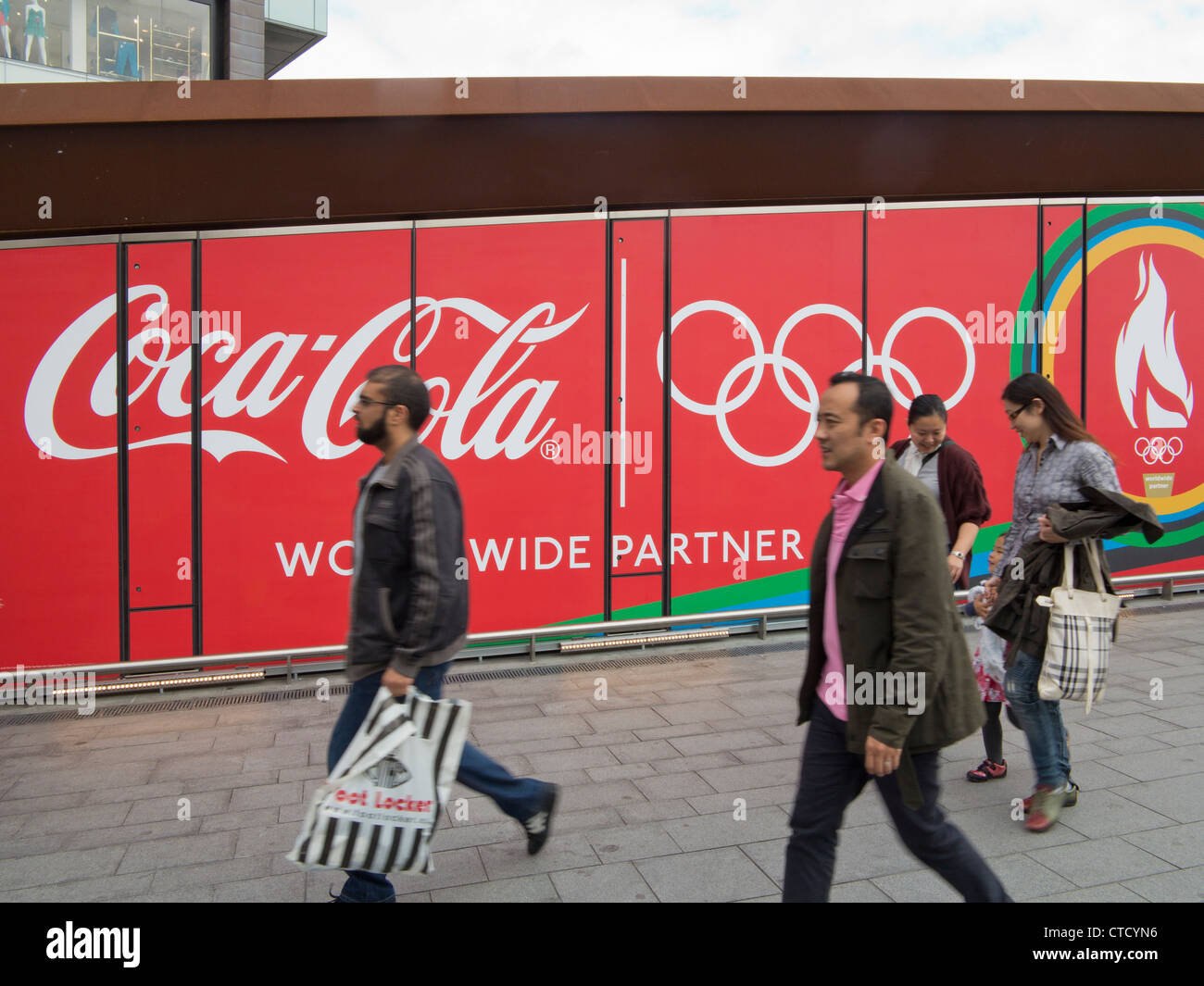 I visitatori di London 2012 Olympic Park con la Coca Cola pubblicità Affissioni Foto Stock