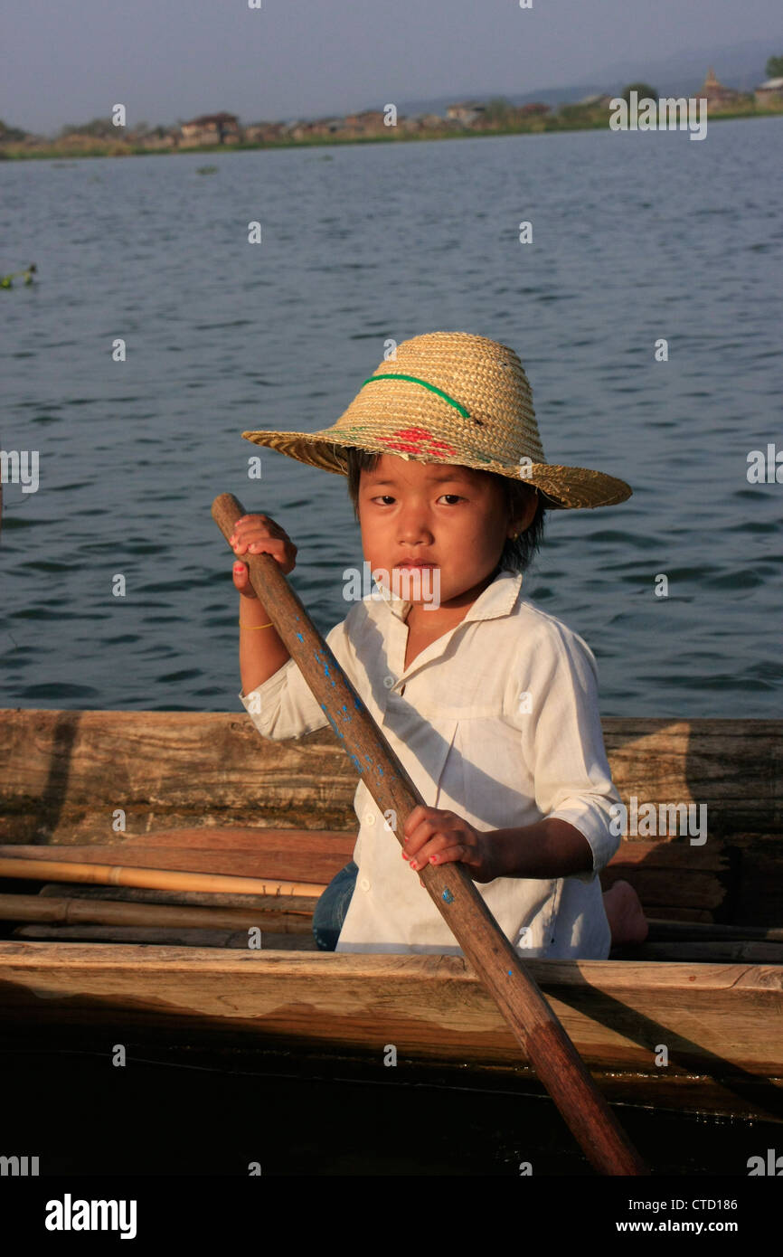 Ragazza birmano canottaggio sul Lago Inle, stato Shan, Myanmar, sud-est asiatico Foto Stock