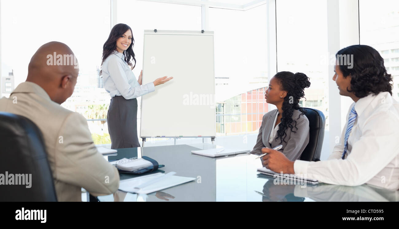 Tre dipendenti serio attento ascolto di una presentazione Foto Stock