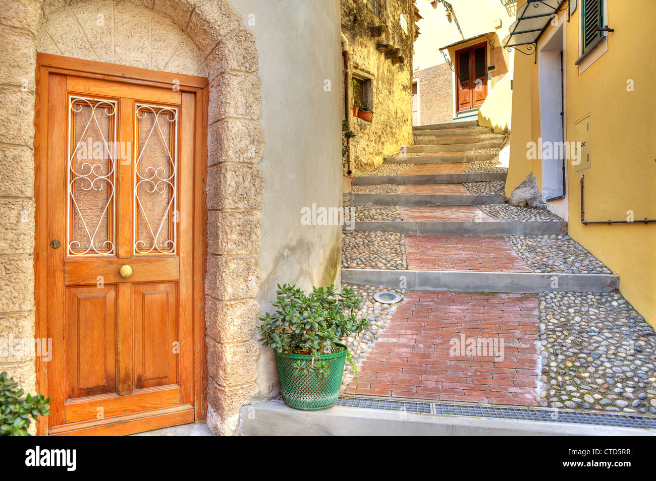 Porta di legno all'ingresso piccola casa su strette strade di ciottoli nella città di Ventimiglia in Liguria, Italia. Foto Stock