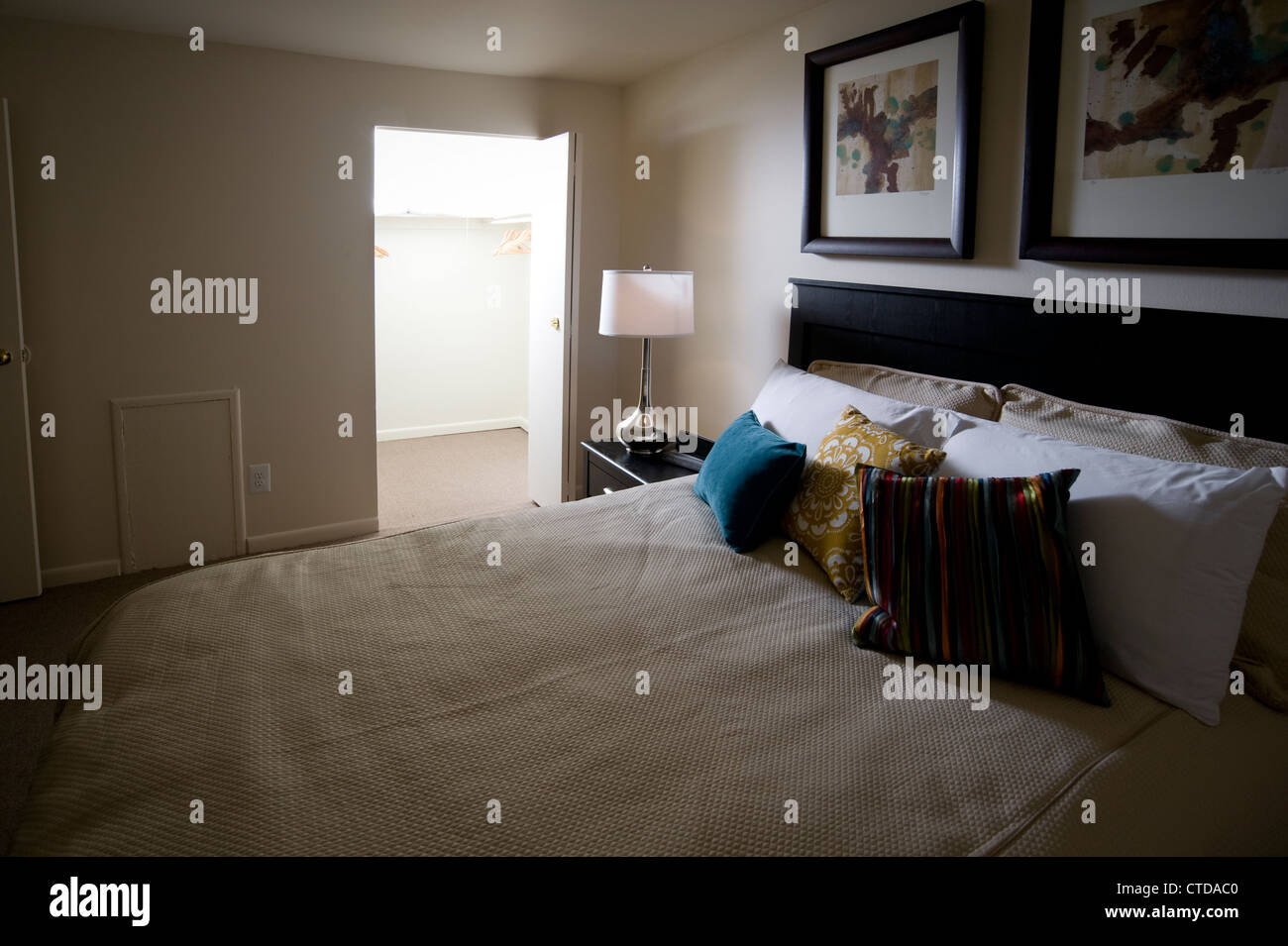 Letto in camera da letto con una luce brillante proveniente dal ripostiglio di notte Foto Stock