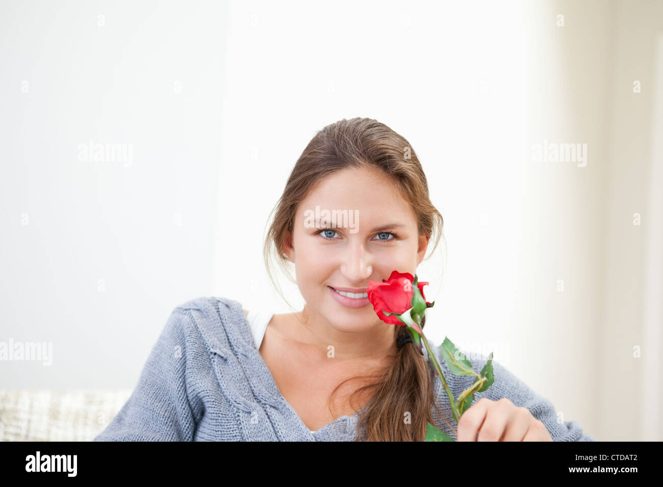 Donna che mantiene una rosa mentre sorridente Foto Stock