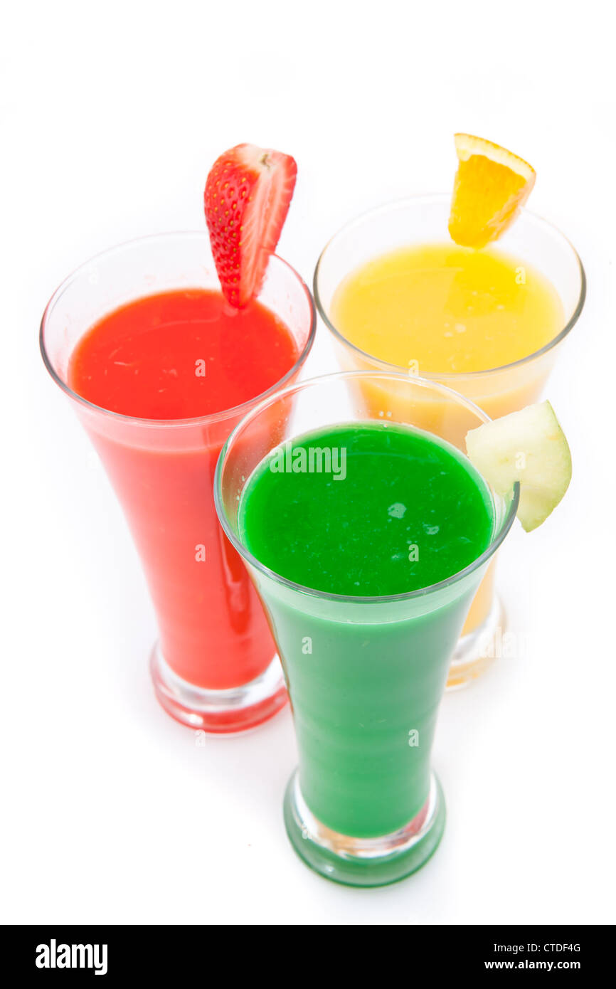 Tre bicchieri pieni di succo di frutta con pezzi di frutta Foto Stock