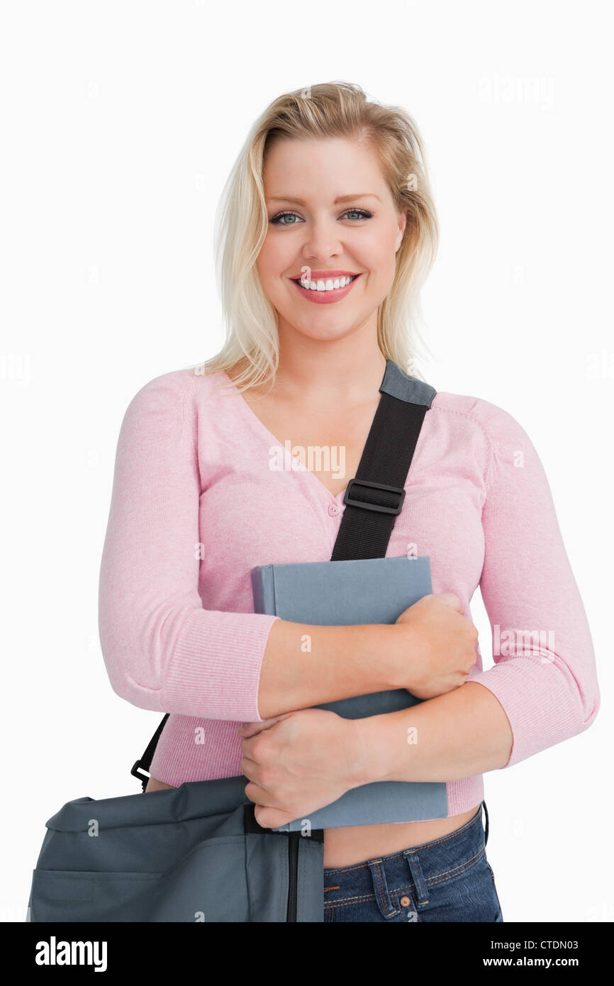 Felice donna bionda in possesso di un libro di scuola Foto Stock