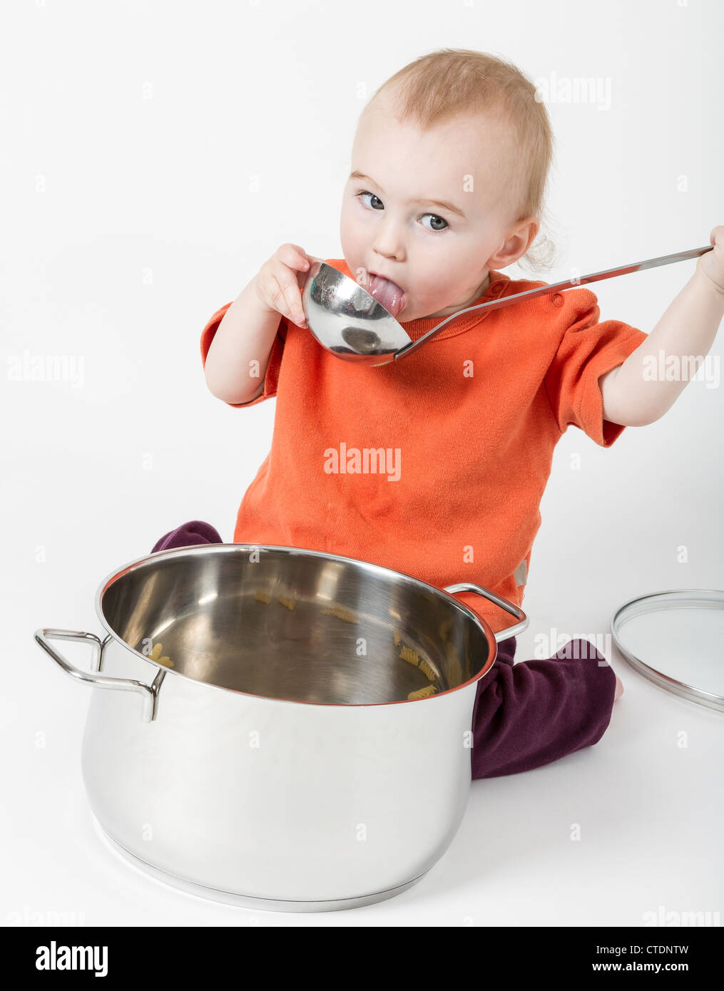 Bambino con grande pentola di cottura isolata su sfondo neutro Foto Stock