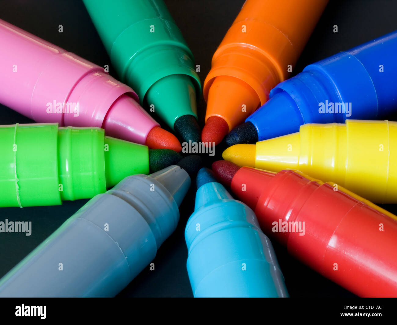 Colorate diverse penne a feltro con tappi off formando un cerchio su sfondo nero Foto Stock