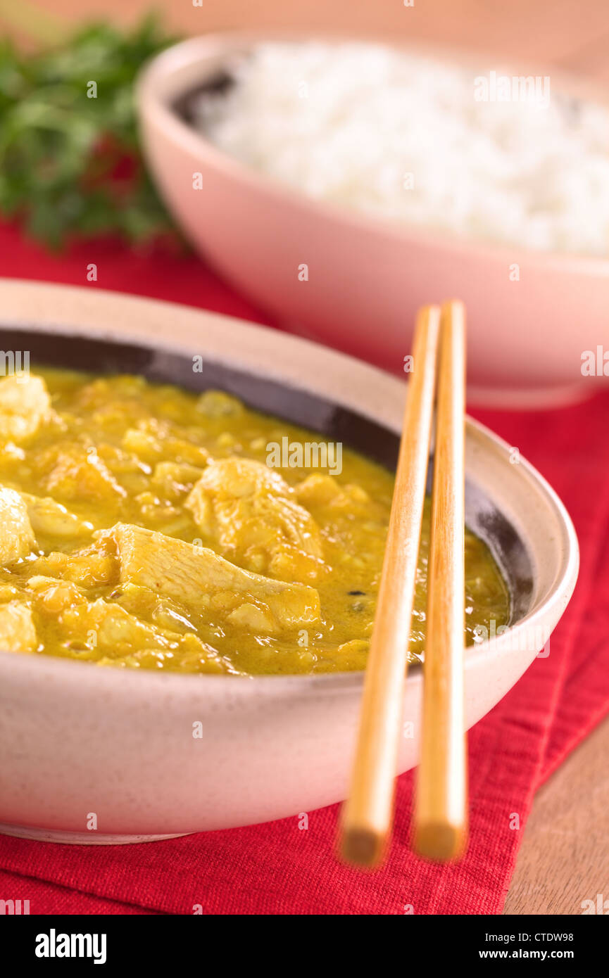 Pollo-mango curry con riso in retro (messa a fuoco selettiva, Focus sul pollo un terzo nella coppa) Foto Stock