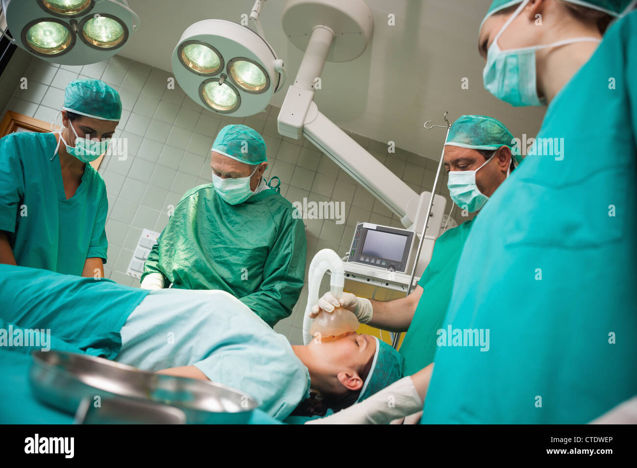 Chirurgo mantenendo una maschera sul volto di una donna Foto Stock