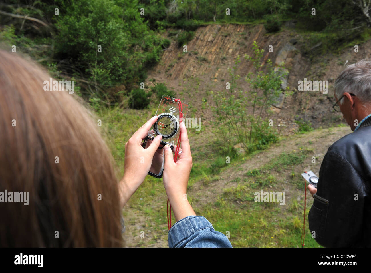 La misurazione dell'angolo di dip e la direzione di inclinazione dei letti piani utilizzando una bussola geologica. Foto Stock