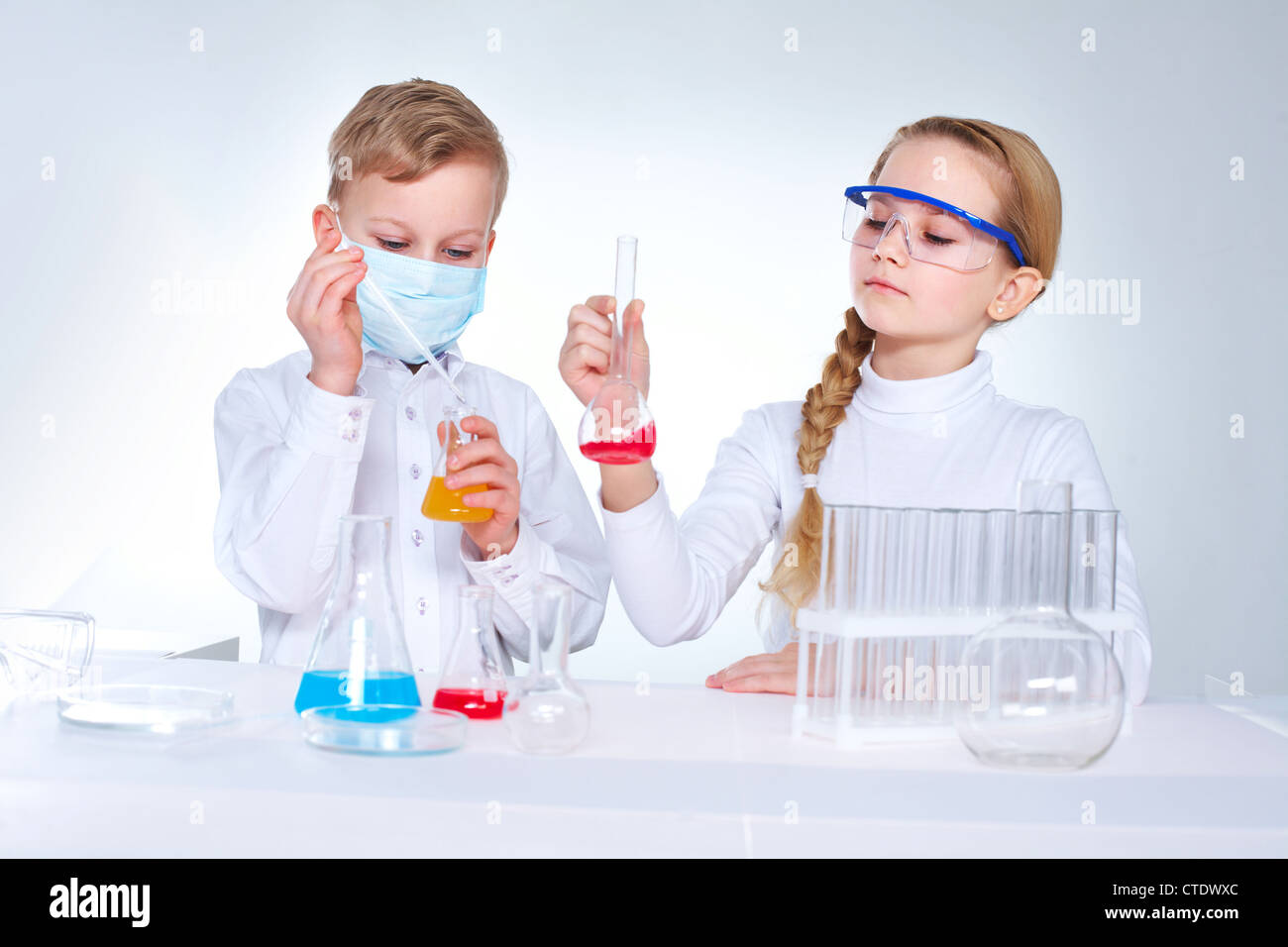 I giovani scienziati di miscelazione di sostanze chimiche nella LAD Foto Stock