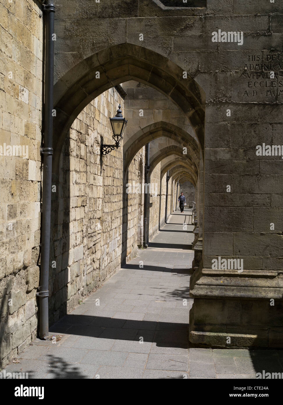 dh Winchester Cattedrale WINCHESTER HAMPSHIRE persona a piedi Winchester Cattedrale archi edificio arco contrafforte chiudi inglese regno unito Foto Stock