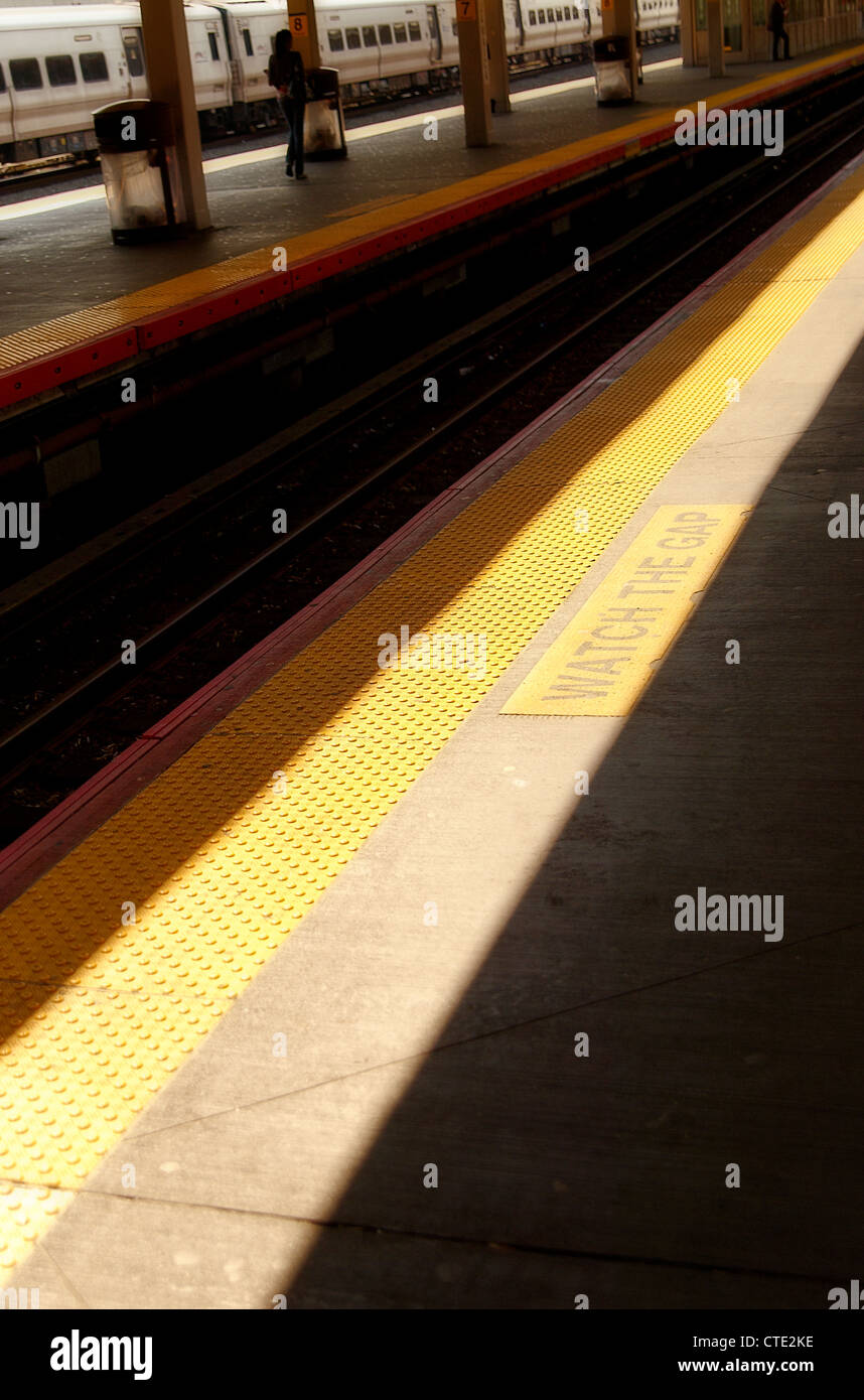 Avviso di colore giallo linee su una stazione ferroviaria platform Foto Stock