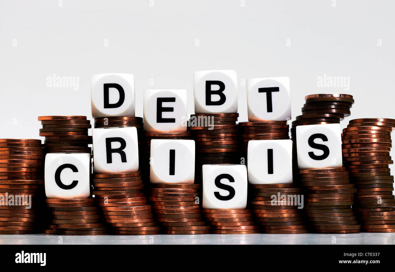 Bilanciamento dei dadi su una pila di monete, ortografia dalla crisi del debito Foto Stock