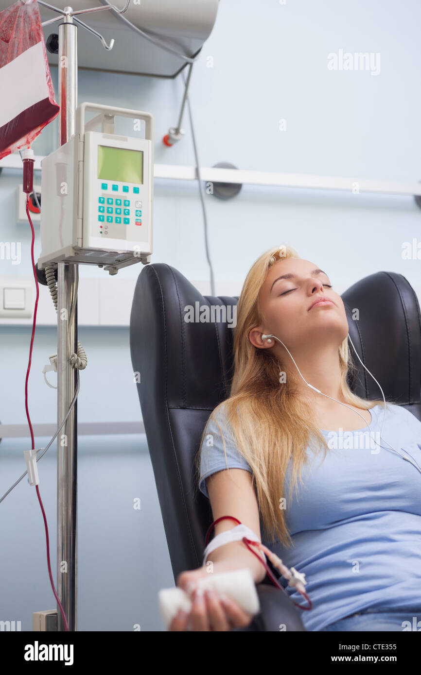 La donna riceve una donazione di sangue durante la seduta Foto Stock