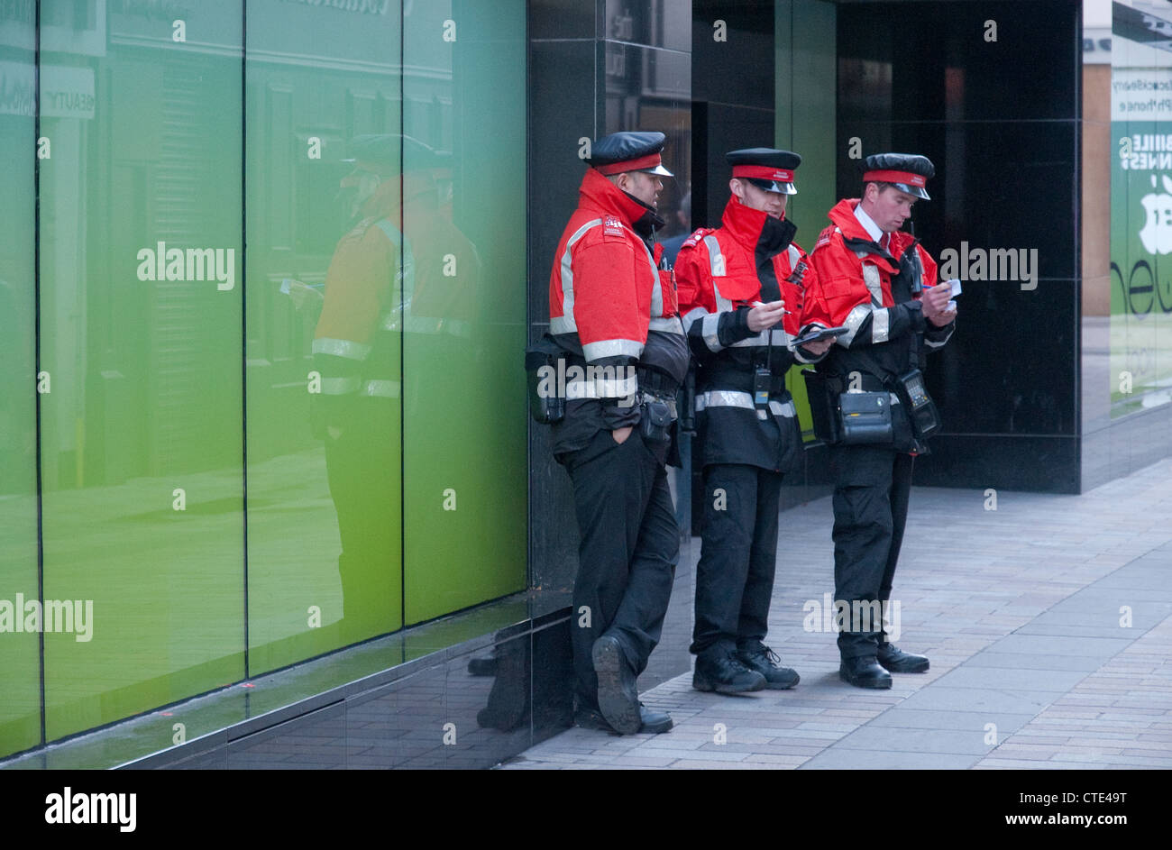 Un gruppo di 3 parcheggio i funzionari di polizia a Belfast, Irlanda del Nord Foto Stock