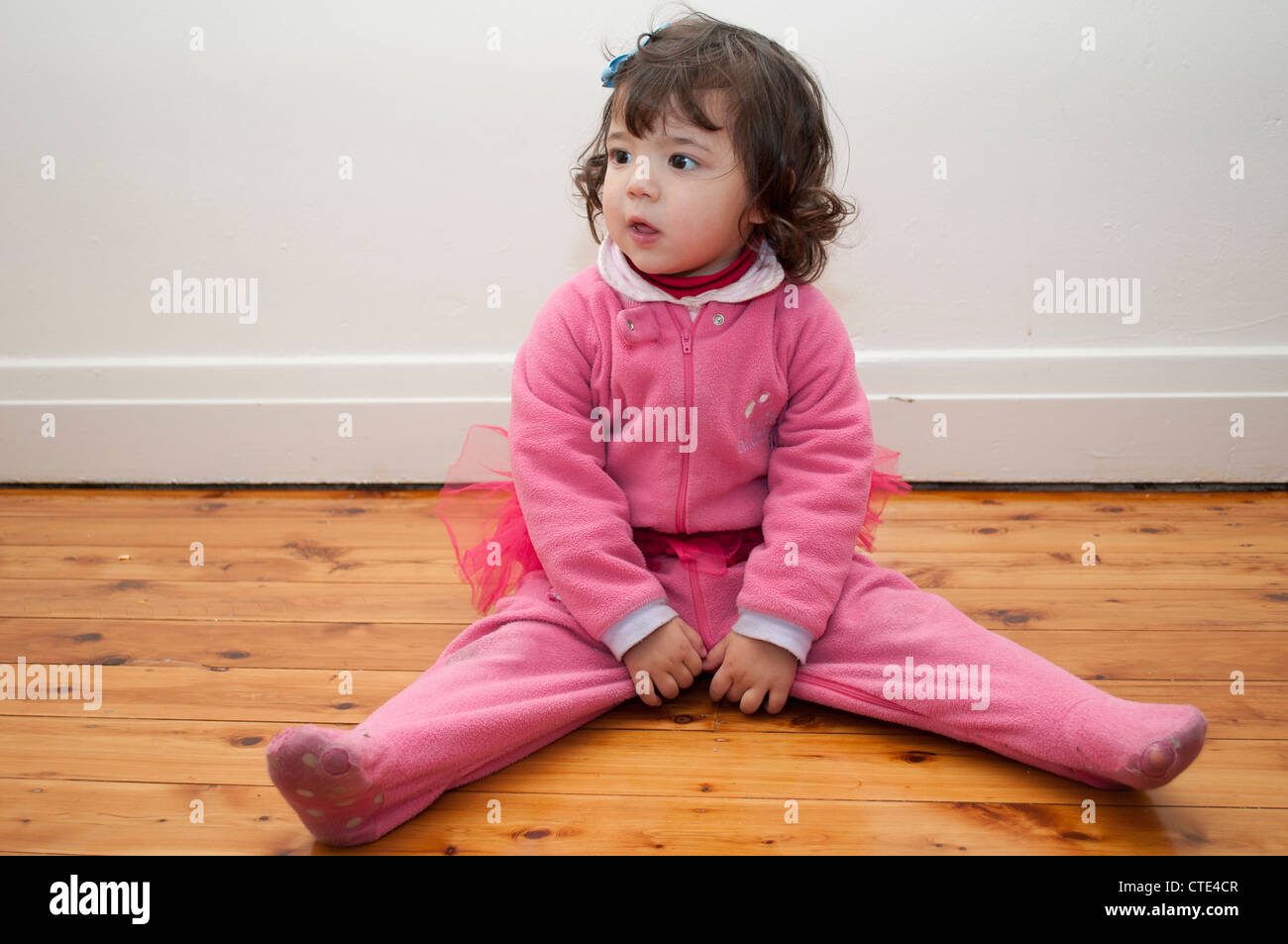 Piccola ragazza seduta sul pavimento Foto Stock