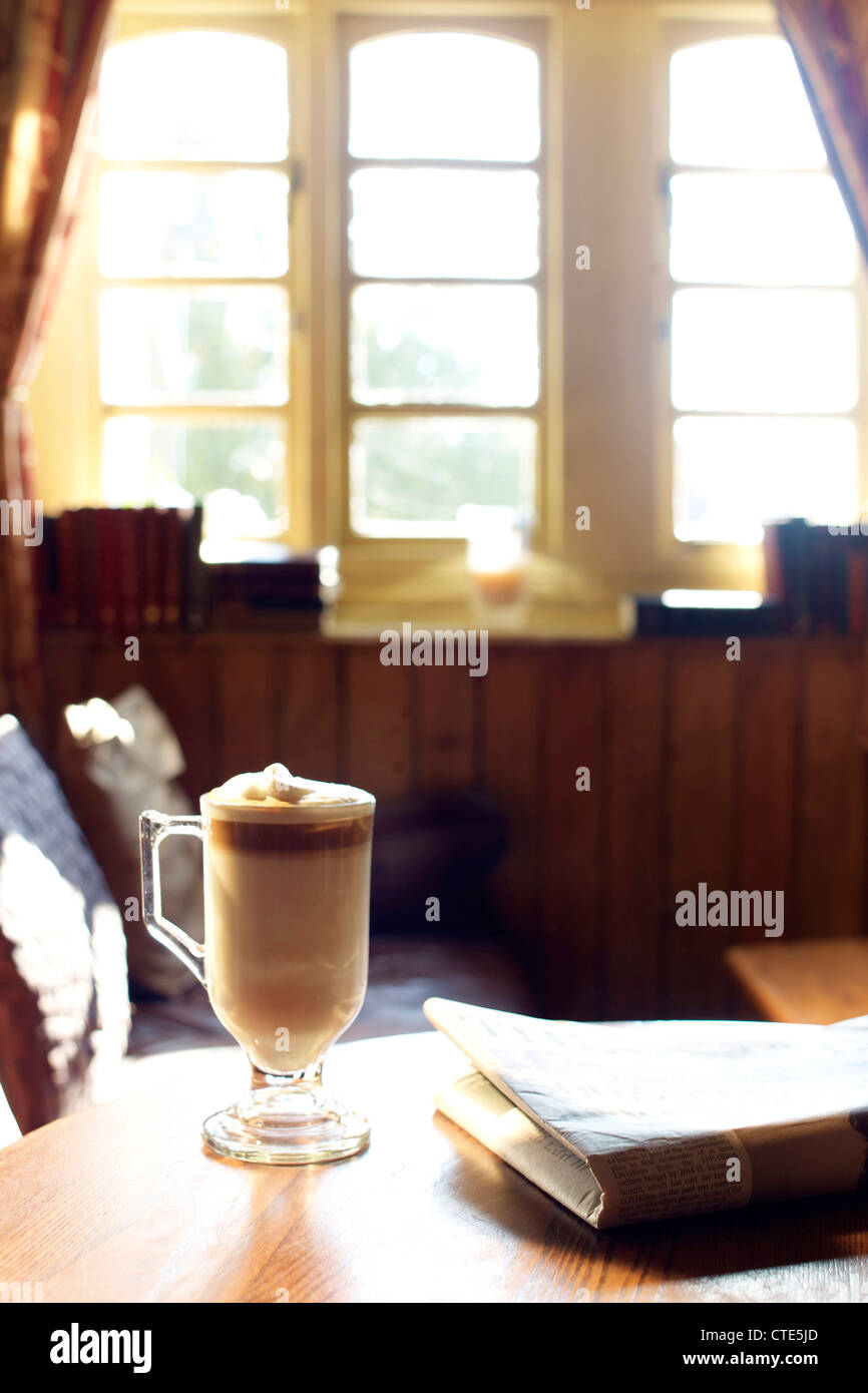 Foto di un caffè / lattte e quotidiano in un pub Foto Stock