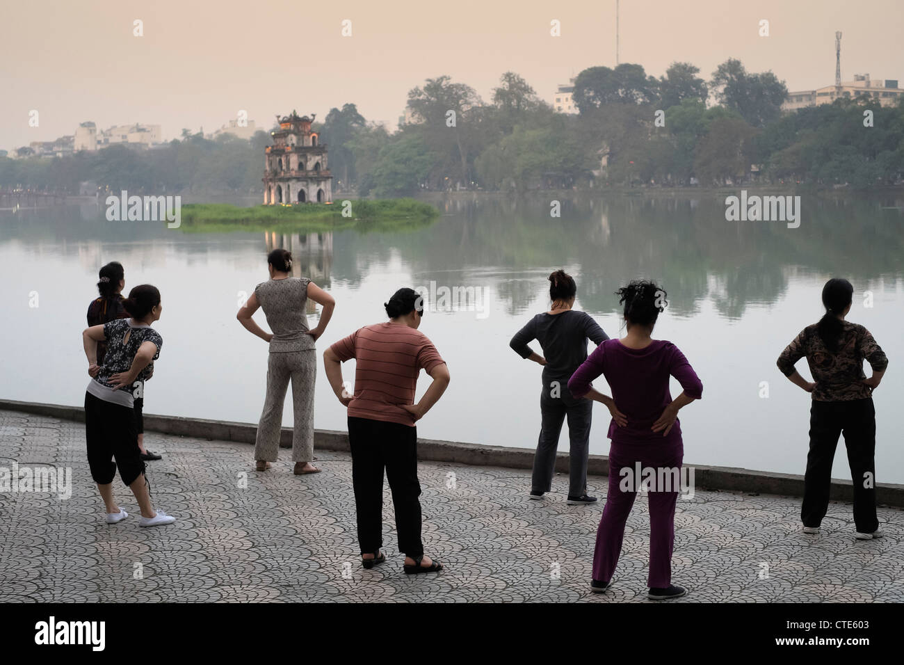 Sera Tai Chi esercita accanto al lago Hoan Kiem in Hanoi Vietnam Foto Stock