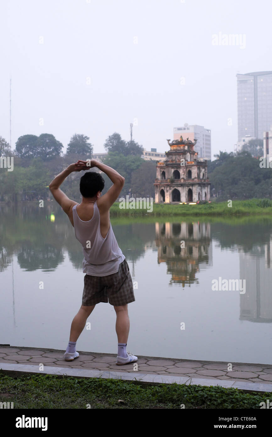 Sera Tai Chi esercita accanto al lago Hoan Kiem in Hanoi Vietnam Foto Stock