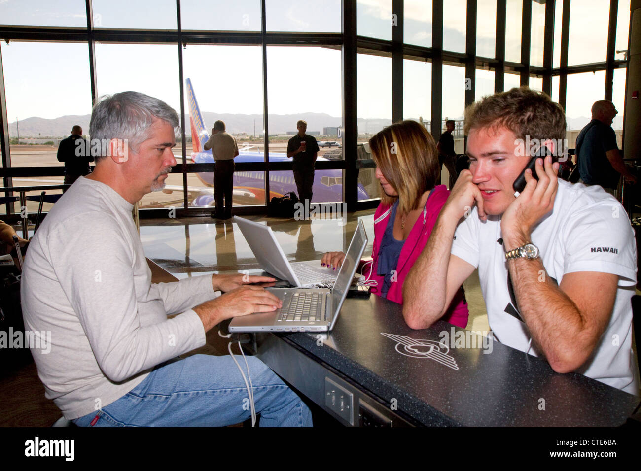 Le persone utilizzano internet wi-fi presso l'Aeroporto Internazionale Sky Harbor di Phoenix si trova nella città di Phoenix, Arizona, Stati Uniti. Foto Stock