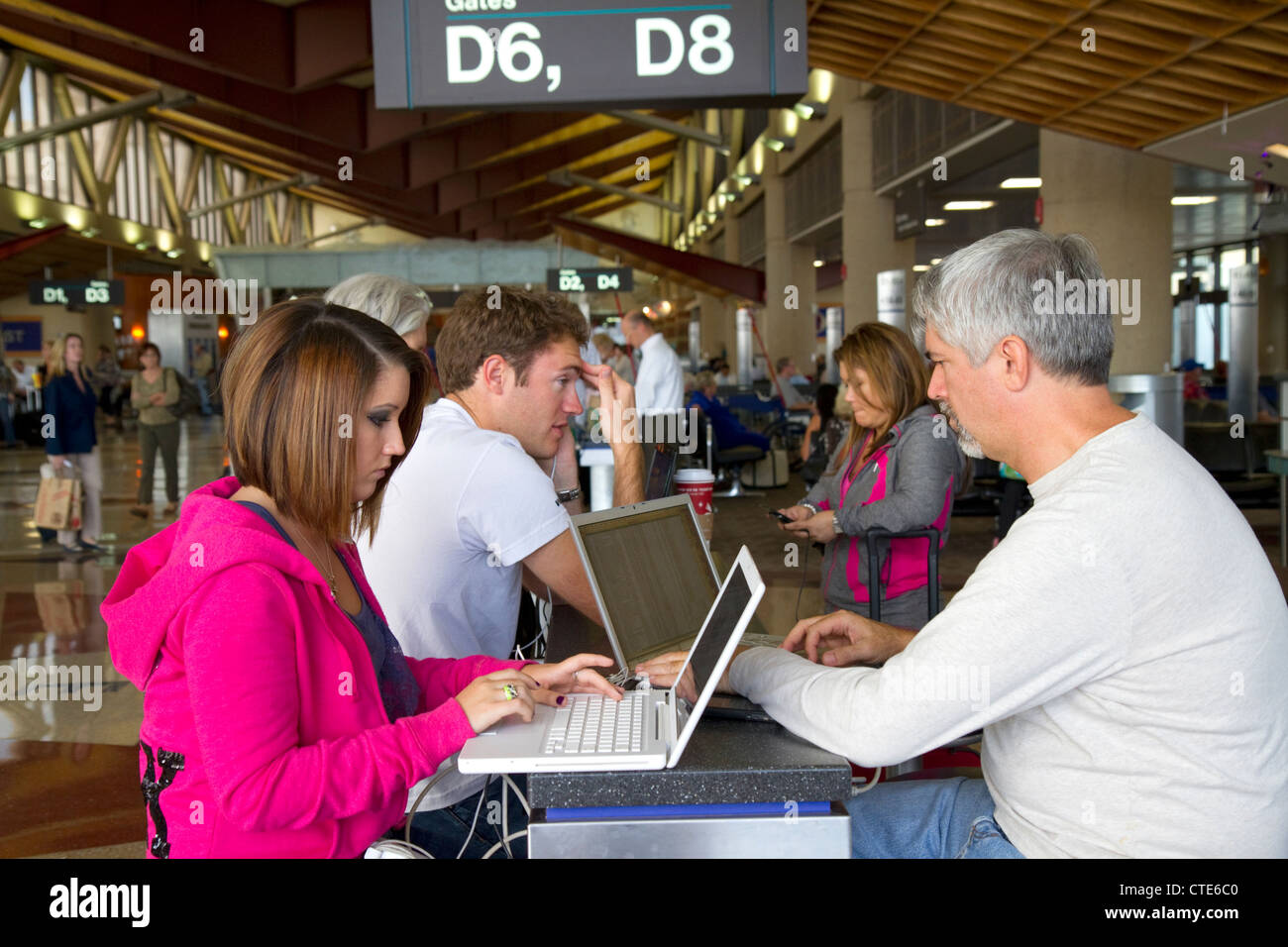 Le persone utilizzano internet wi-fi presso l'Aeroporto Internazionale Sky Harbor di Phoenix si trova nella città di Phoenix, Arizona, Stati Uniti. Foto Stock