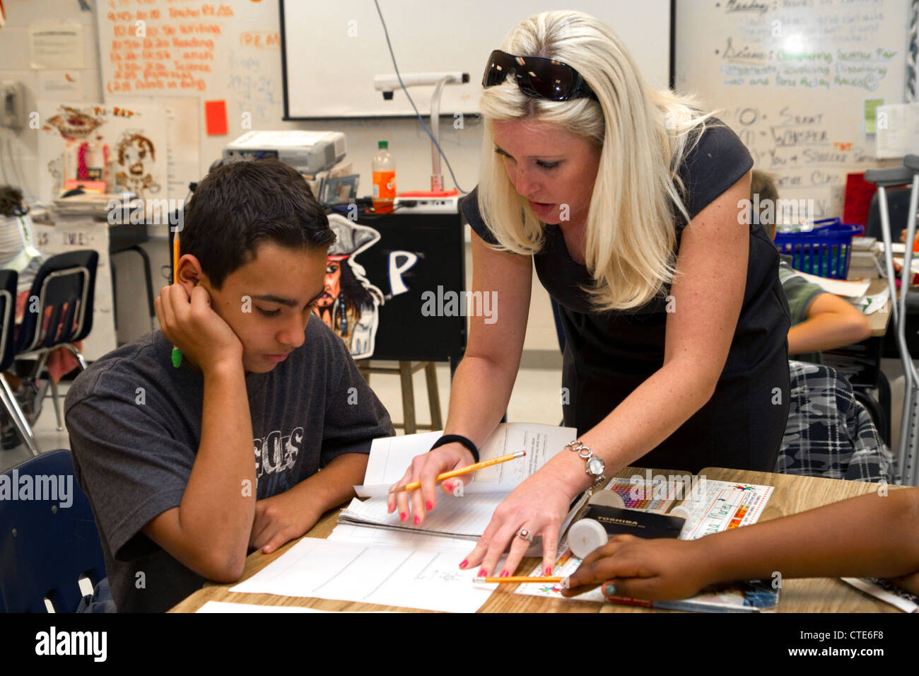 Insegnante femminile aiutando gli studenti in una quarta classe di qualità a un pubblico di scuola elementare in Brandon, Florida, Stati Uniti d'America. Foto Stock