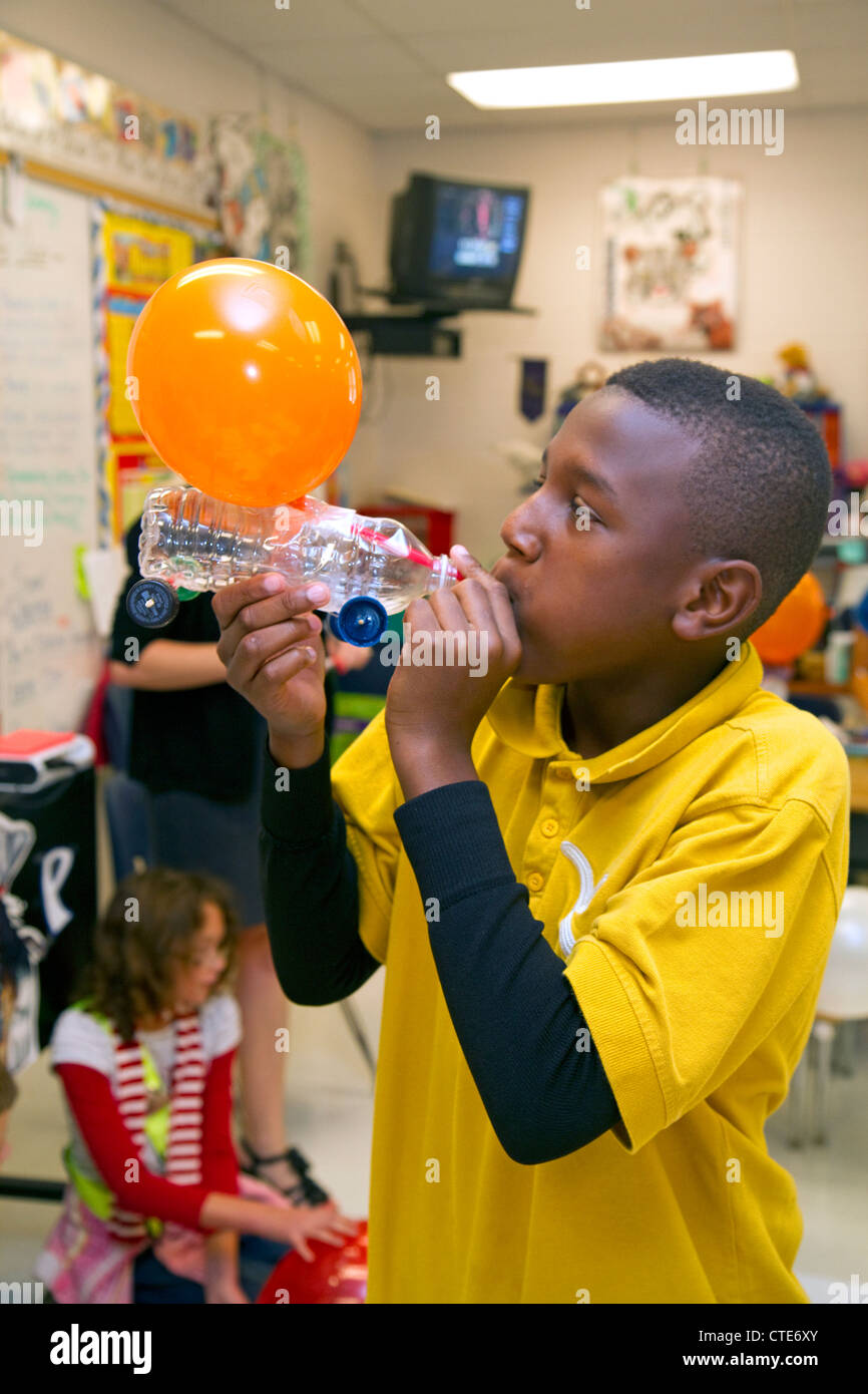 Lo studente che soffia su un palloncino come parte di un esperimento di scienza a un pubblico scuola elementare a Brandon, Florida, Stati Uniti d'America. Foto Stock