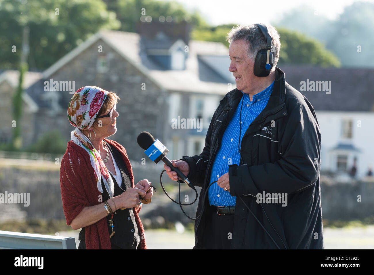 Il veterano della BBC Radio Cymru presenter HYWEL GWYNFRYN intervistando una donna vivono sulla lingua gallese radio, Wales UK Foto Stock