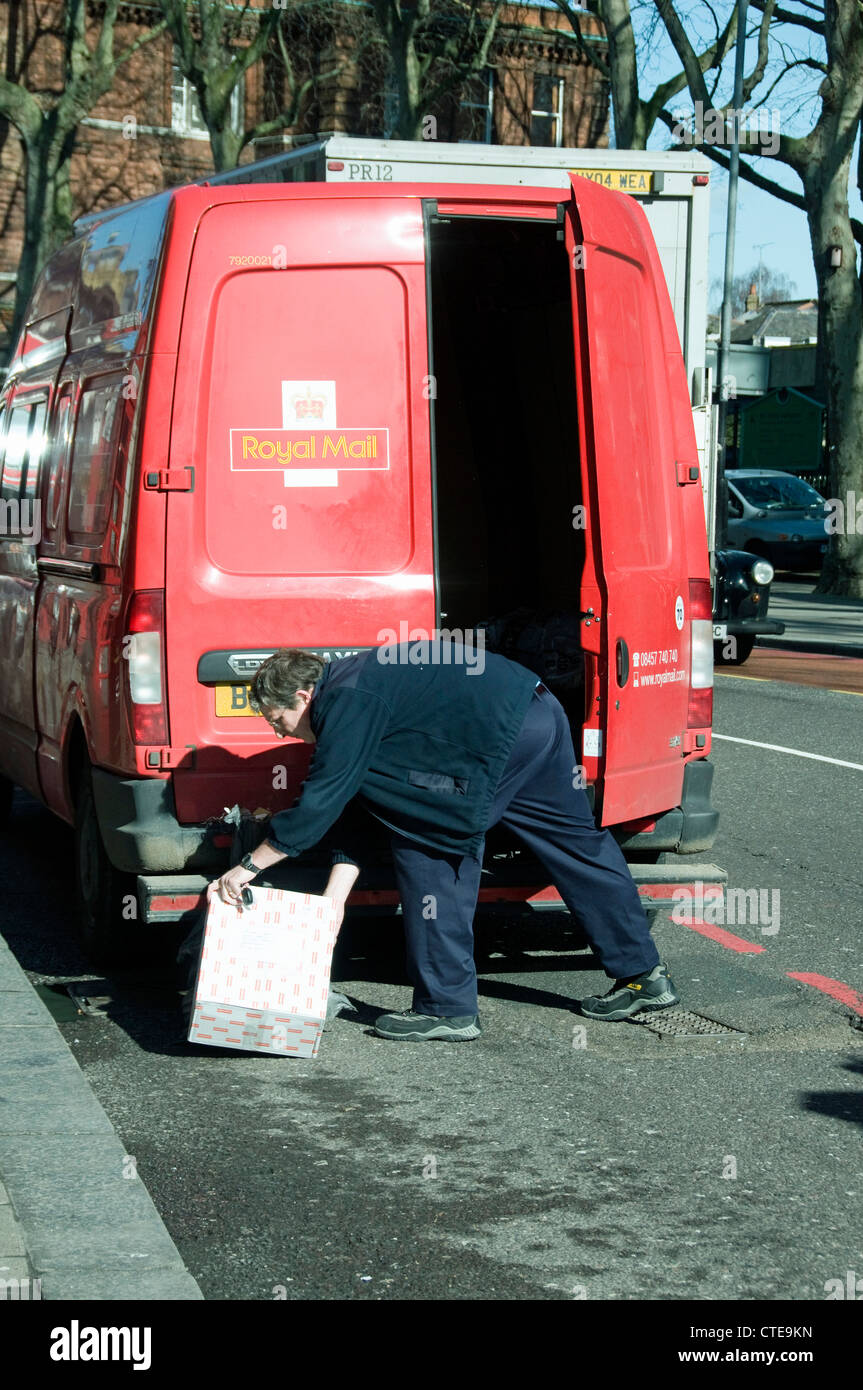 Royal Mail postino circa per mettere il pacco nel retro di un post van in Upper Street Islington Londra Inghilterra REGNO UNITO Foto Stock