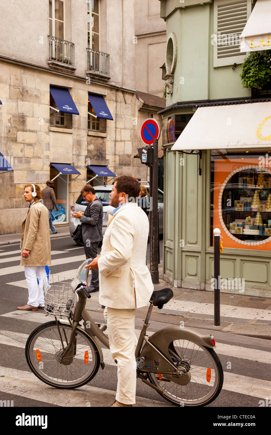 Ben vestito uomo su una bici a noleggio, Saint-Germain-des-Pres Parigi Francia Foto Stock