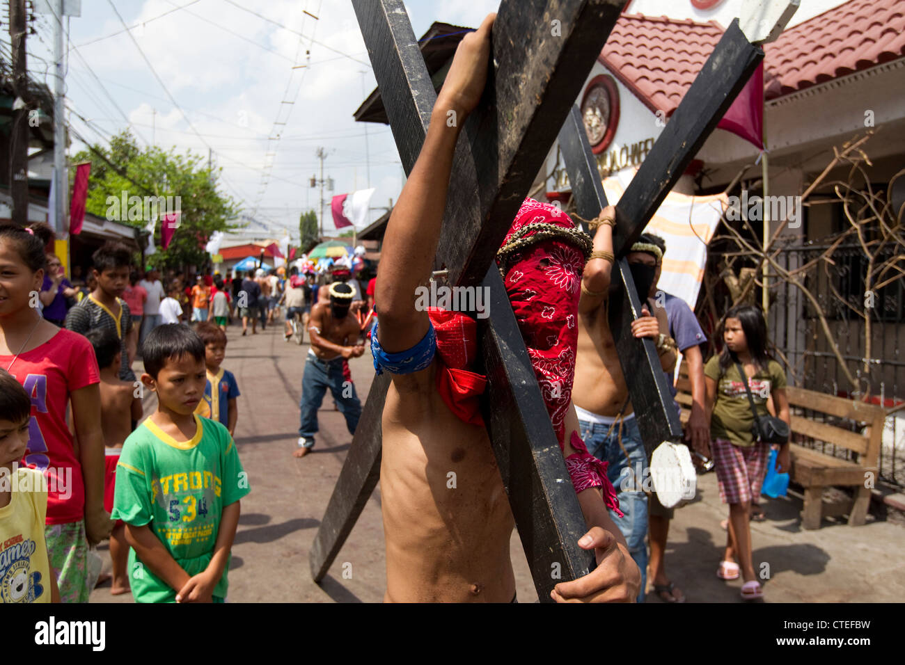 Penitenti portano croci di legno del Giovedì Santo,parte della settimana santa, Barangay Lourdes Northwest,Angeles City,Pampanga,Philipp Foto Stock