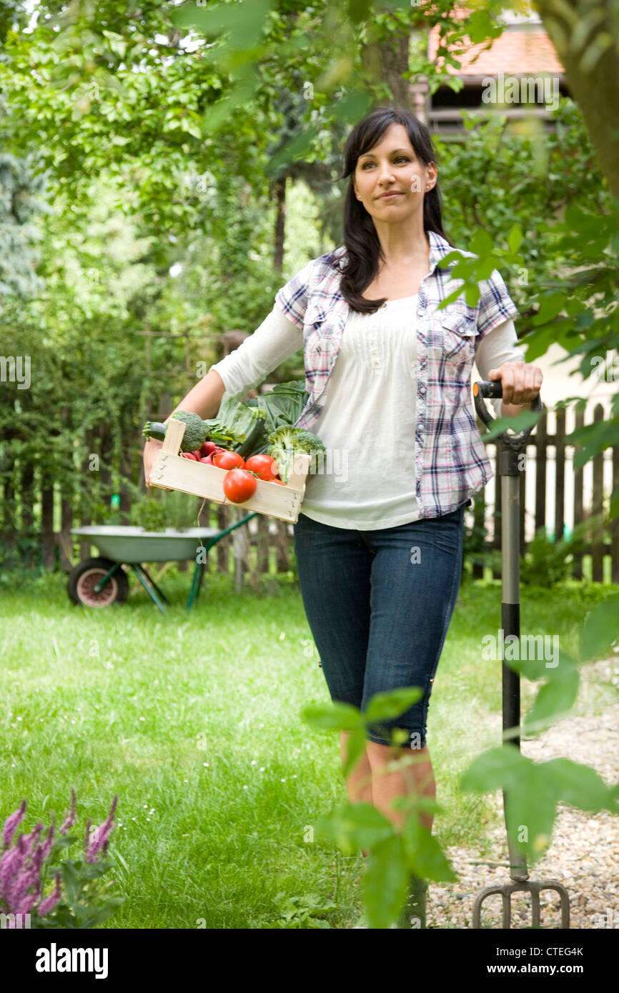 Donna che trasportano verdure fresche in giardino Foto Stock