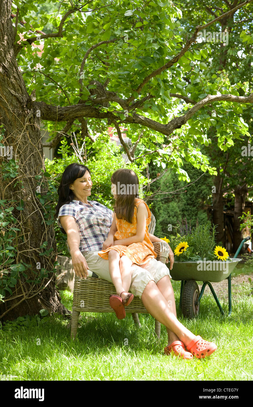 Madre e figlia rilassarsi in giardino Foto Stock